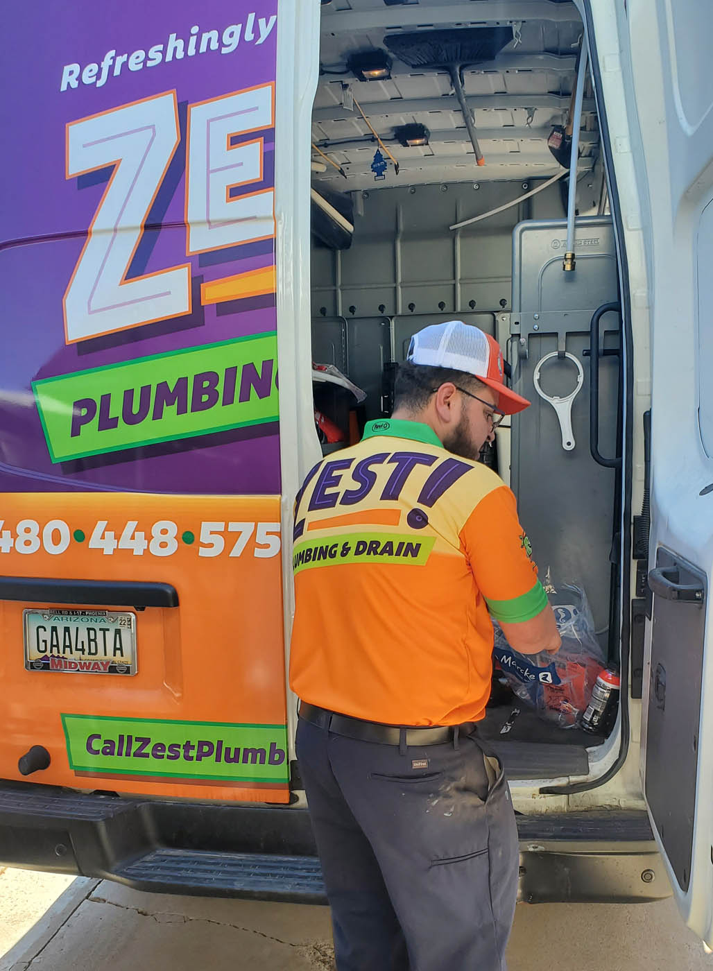 A Zest Plumbing & Drain technician getting equipment out of their truck to work on a water filter service in Scottsdale, AZ.