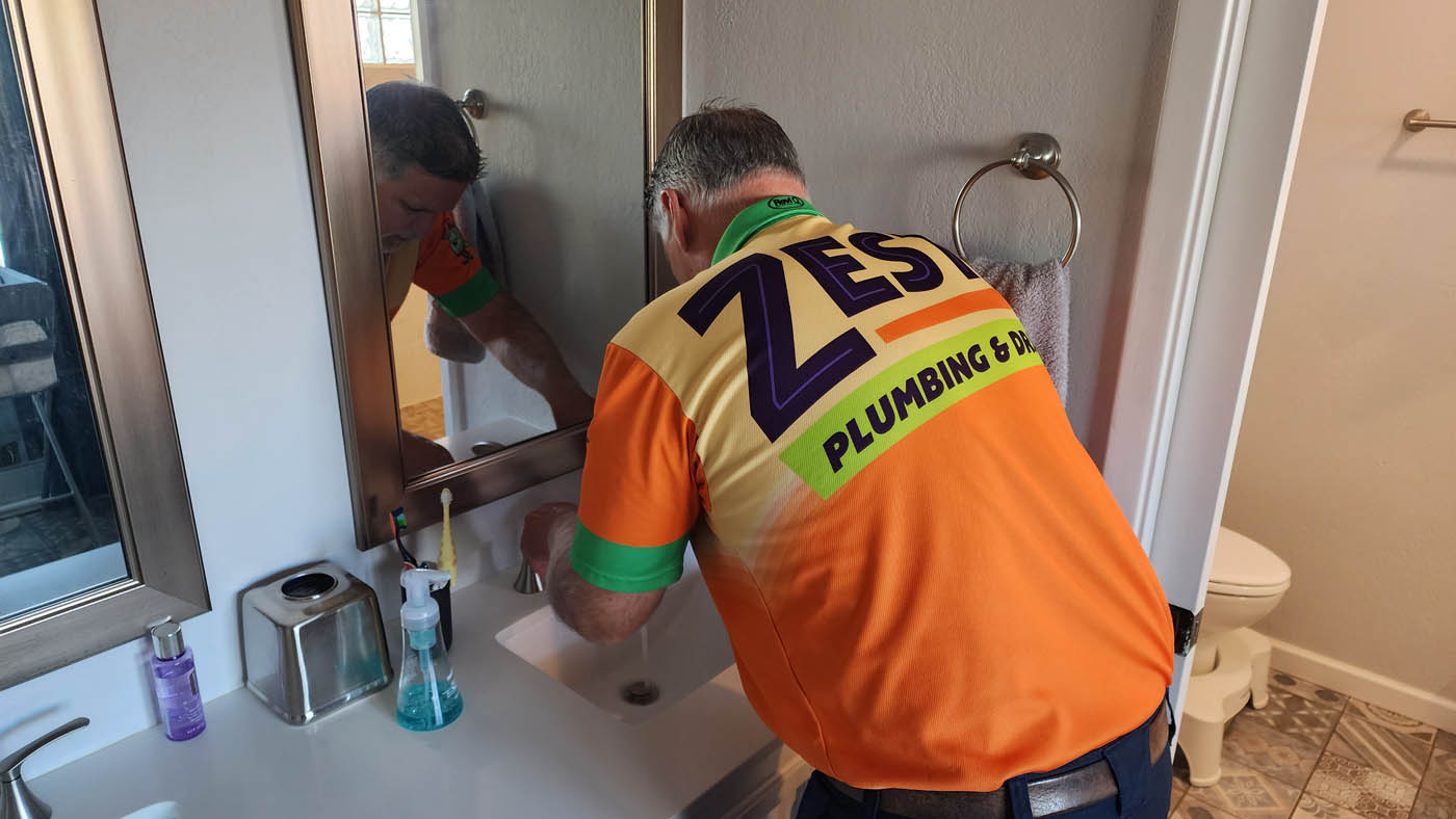 A Zest Plumbing & Drain expert working on bathroom plumbing - contact Zest Plumbing & Drain, your trusted plumbing contractors in Arizona, for any plumbing service you need today.