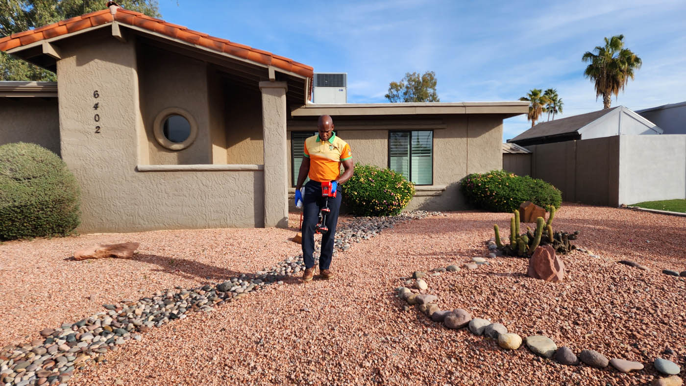 A Zest Plumbing & Drain technician working outside the a residential home in Arizona.