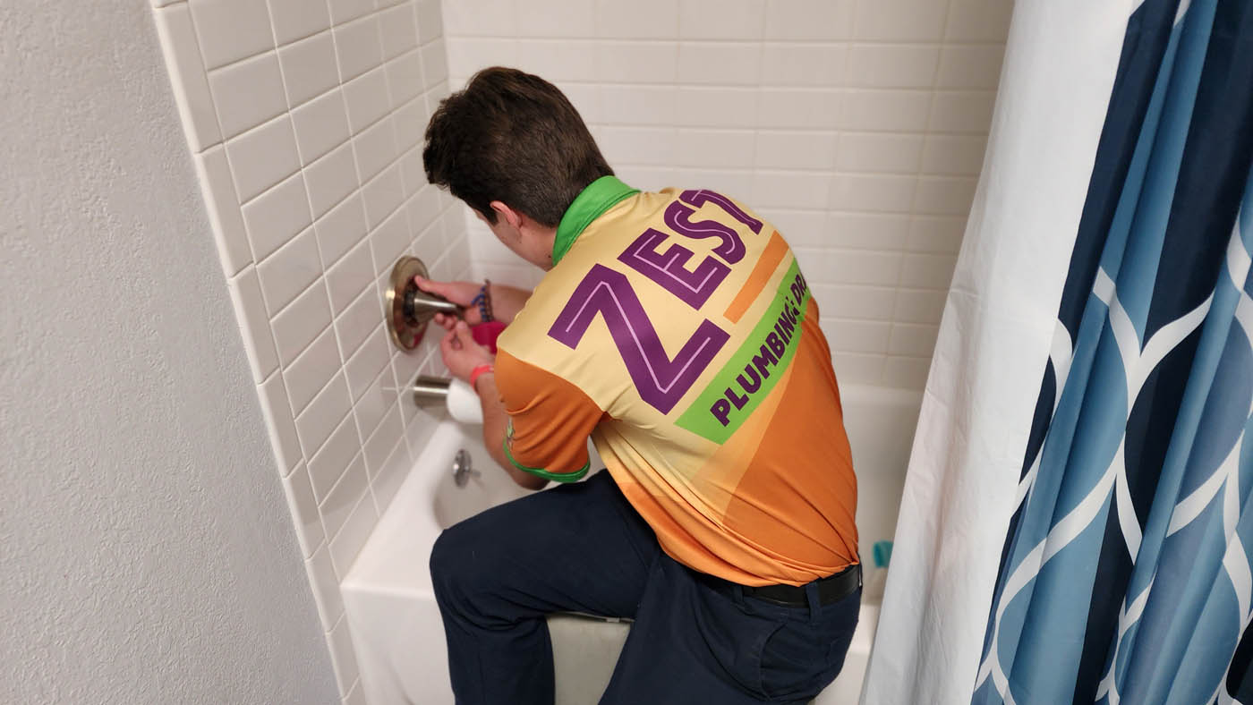 A Zest residential plumber in Scottsdale, AZ providing plumbing services for a shower faucet.