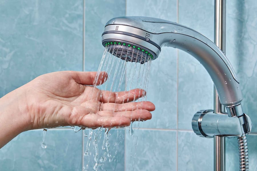 Hand feeling for water to get hot from the showerhead.